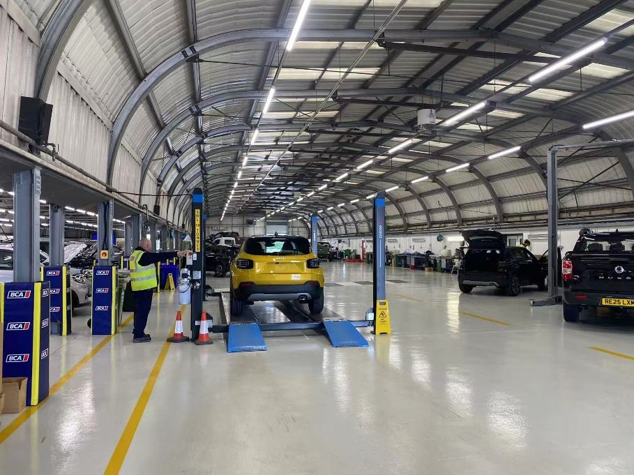 Vehicle preparation workshop with lifts and a vehicle under inspection