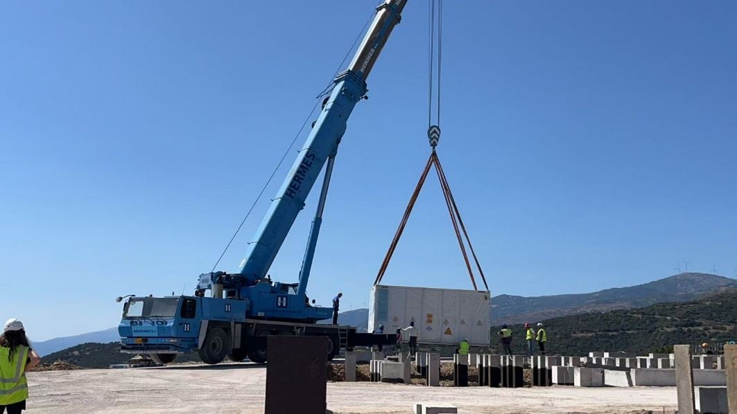Crane lifting a battery storage container into position