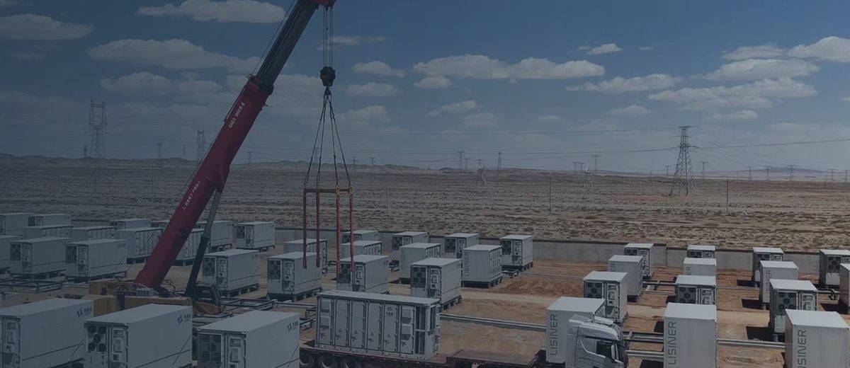Kran setzt eine Batteriespeichereinheit auf einer Netzspeicheranlage ab